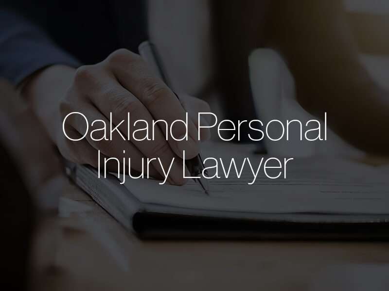 A lawyer writing on paper with the text "Oakland Personal Injury Lawyer" superimposed